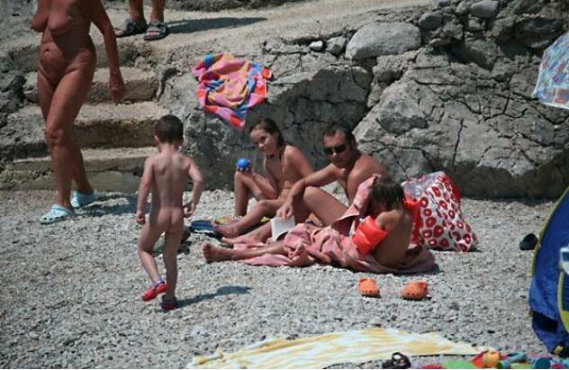 Nudists sunbathe on a beach [Nudism-Planet]